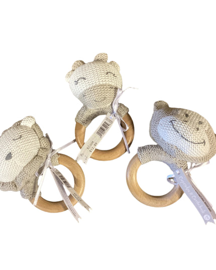 Three baby teething rings with knitted animal heads on a wooden surface